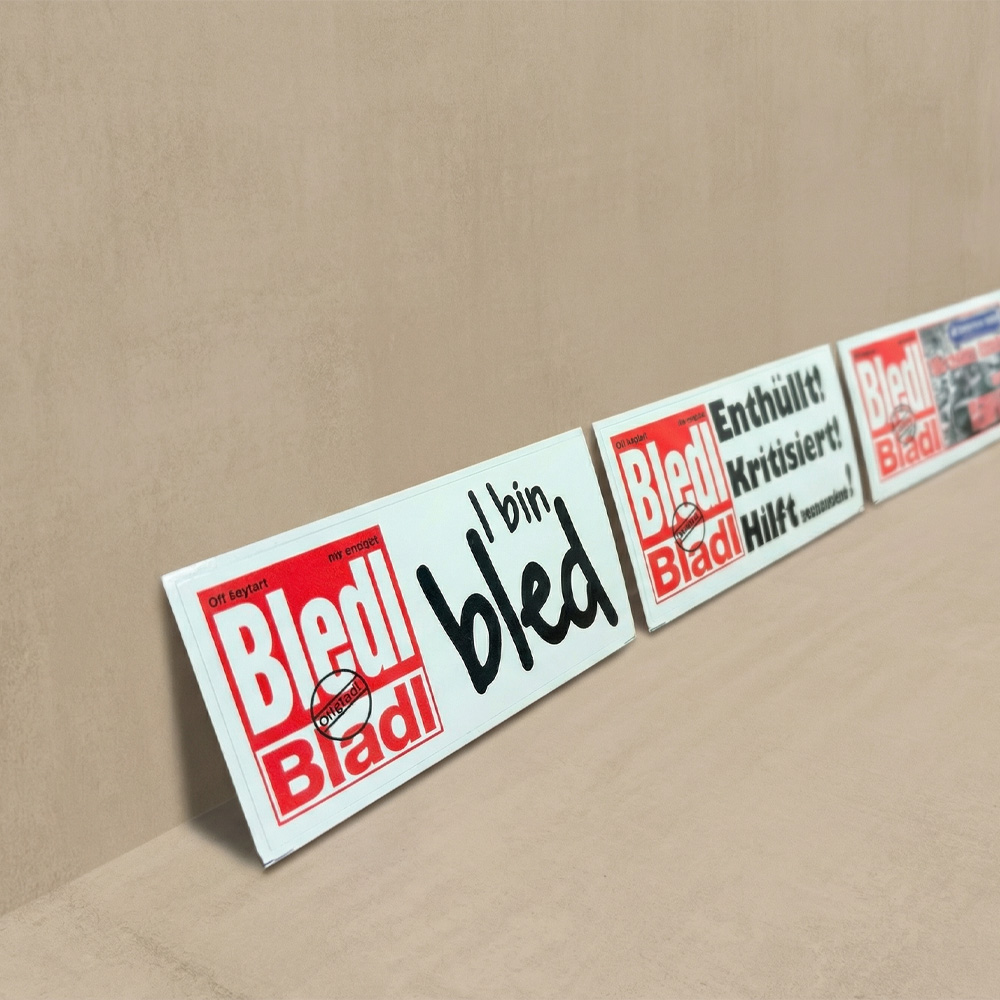 3 verschiedene rechteckige Aufkleber mit einer roten Aufrschift in einem Block 