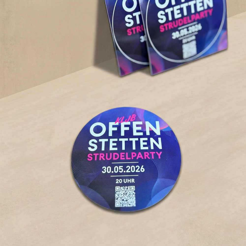 Ein runder blauer Aufkleber mit der weiß/pinken Aufschrift 