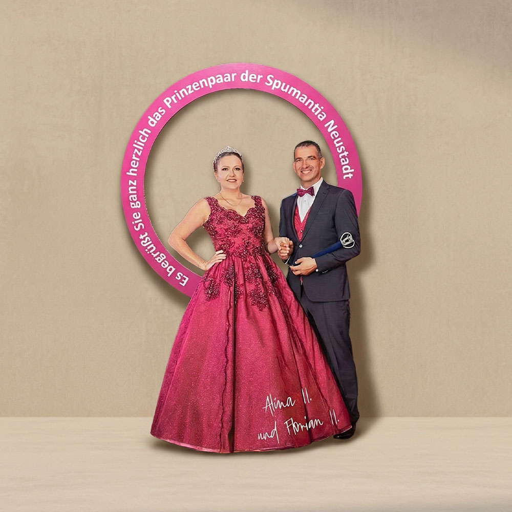 Ein Pappaufsteller, von einer CNC ausgefräst, von einem Tanzpaar in roten Ballkleid und grauen Anzug mit roter Fliege als 