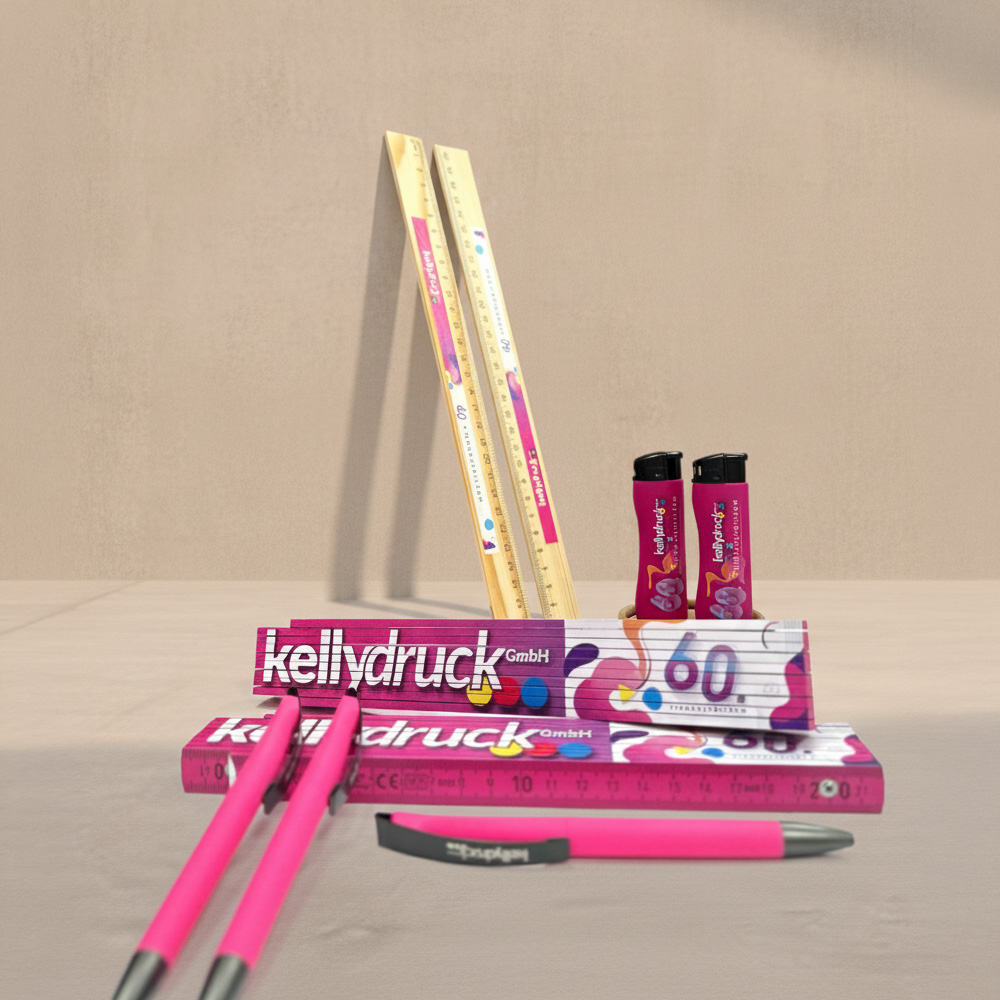 Eine Zusammenstellung von Werbeartikeln für das 60. Jährige Jubiläum der Firma Kelly Druck bestehend aus zwei Holzlineale, zwei pinke Feuerzeuge mit schwarzem Kopf, zwei Meterstäbe mit einer großen Abbildung des Logos von 