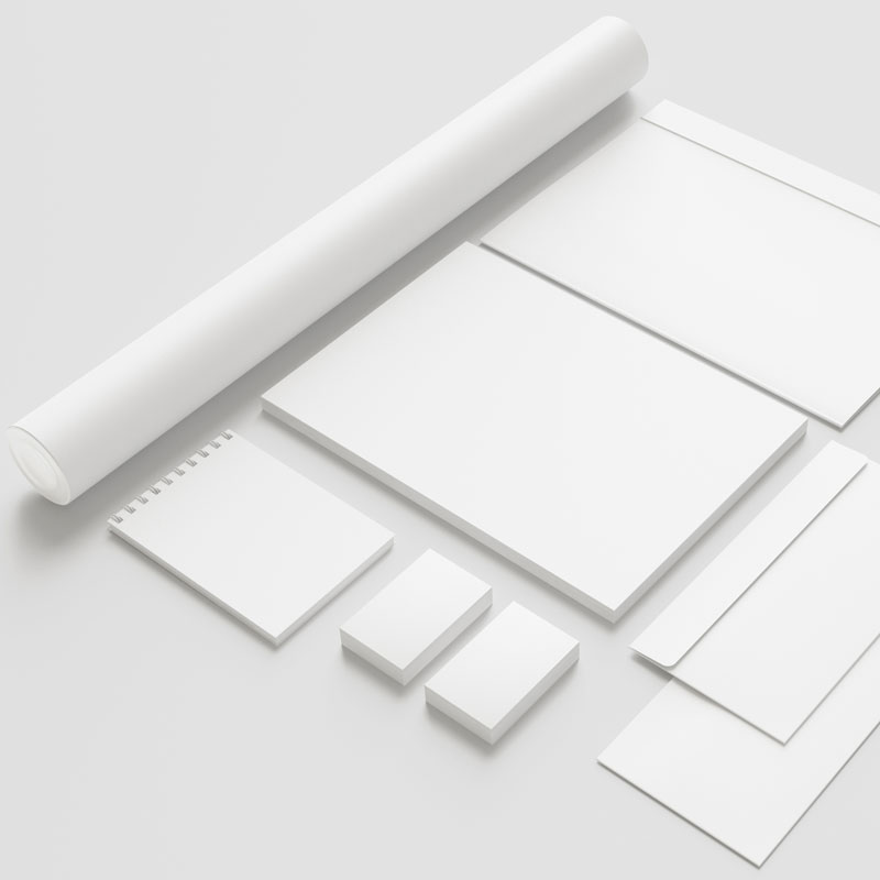 Eine Übersicht von weißen blanko Visitenkarten, Block, Briefppaier, Briefkuvert und Planrolle.